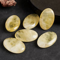 "Polished Citrine palm stone, warm golden-yellow translucent crystal on palm — manifestation stone for wealth and joy"
