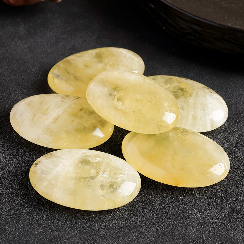 "Polished Citrine palm stone, warm golden-yellow translucent crystal on palm — manifestation stone for wealth and joy"
